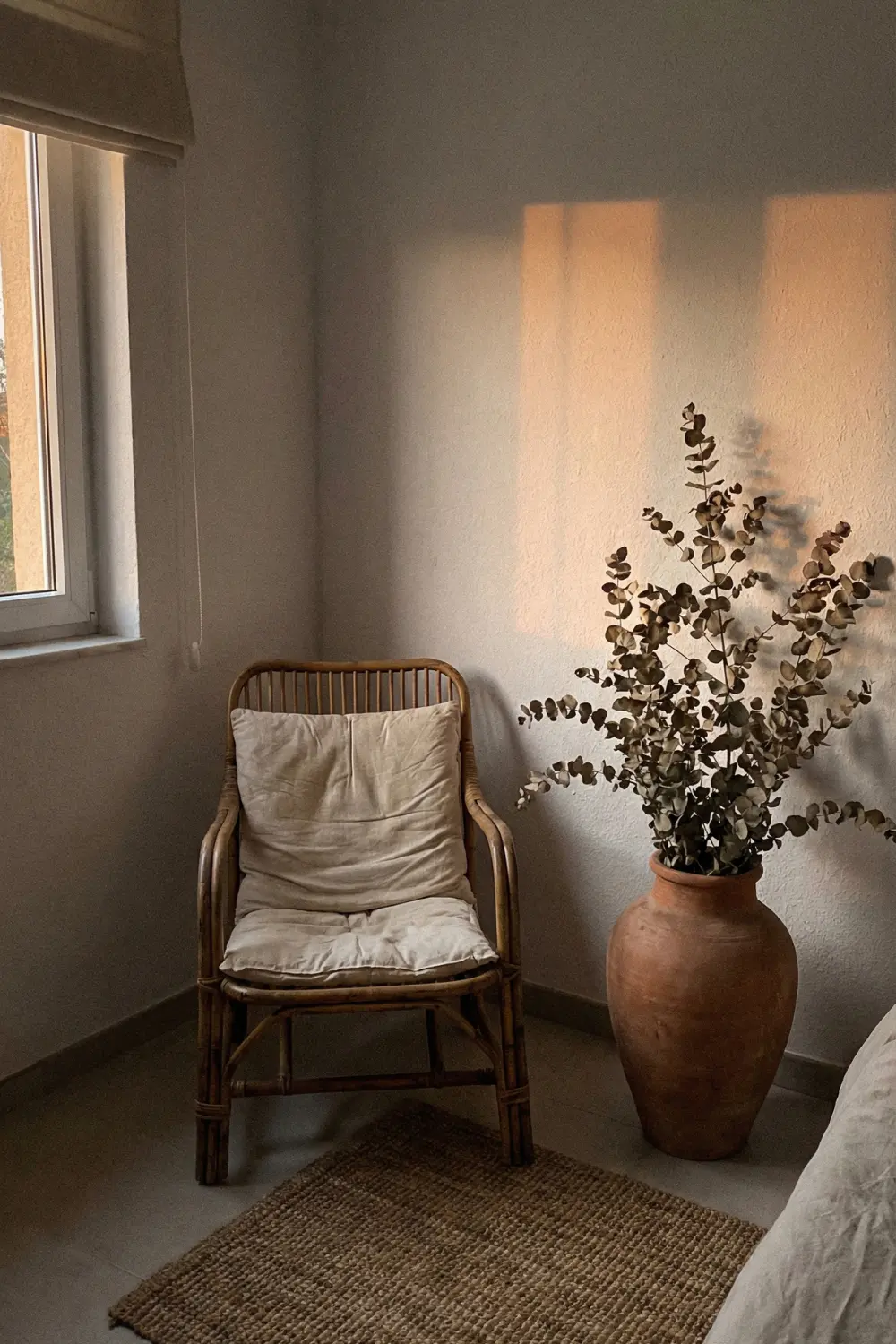 Boho empty corner decor with rattan chair dried eucalyptus and terracotta floor vase