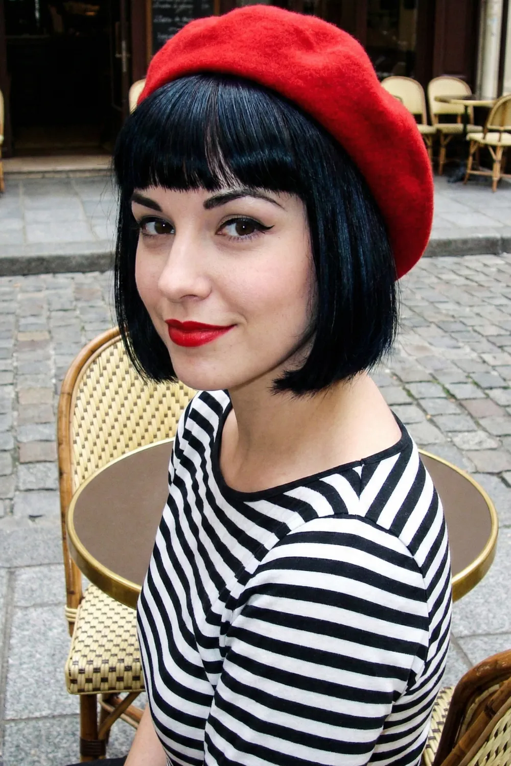 Woman with jet black French bob and blunt straight bangs