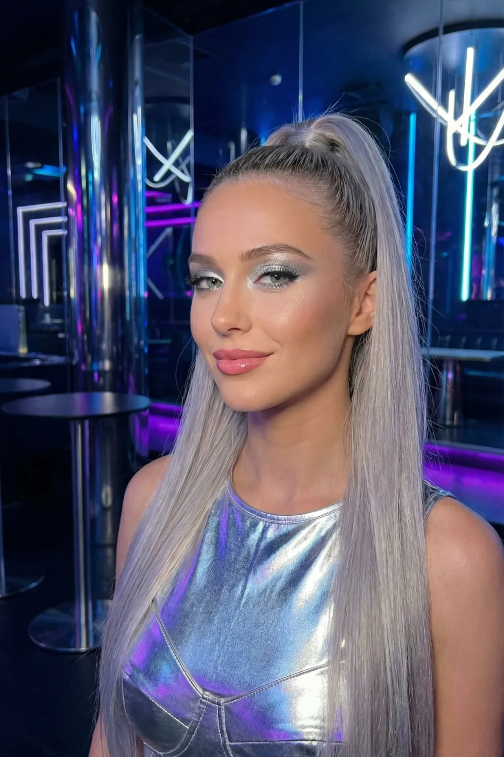 Woman with long cool silver blonde hair and white grey tones in ponytail