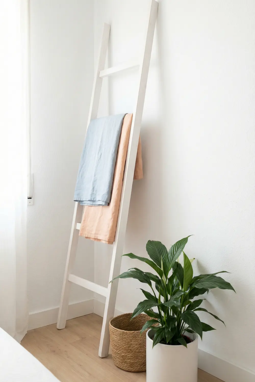 Fresh empty corner decor with white decorative ladder peace lily and woven basket
