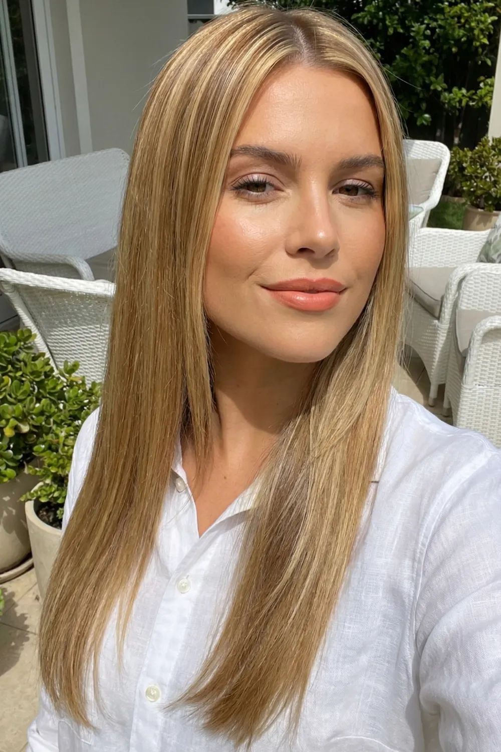 Woman with long golden butter blonde hair and honey highlights