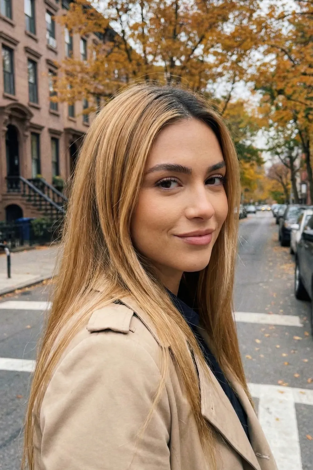 Woman with long honey blonde hair and dark shadow root