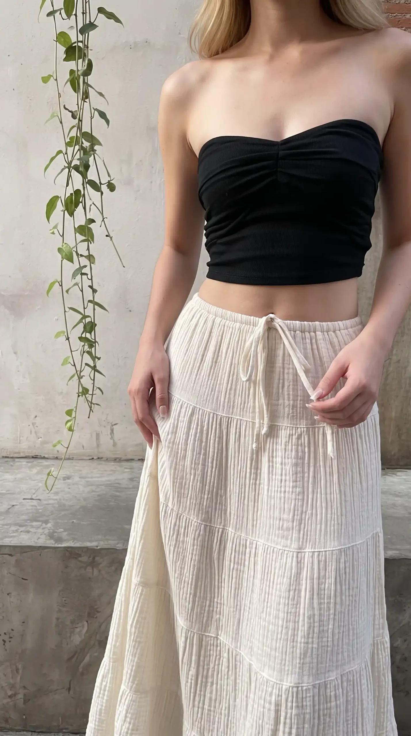 Woman wearing black ruched bandeau crop top with cream gauze tiered drawstring maxi skirt