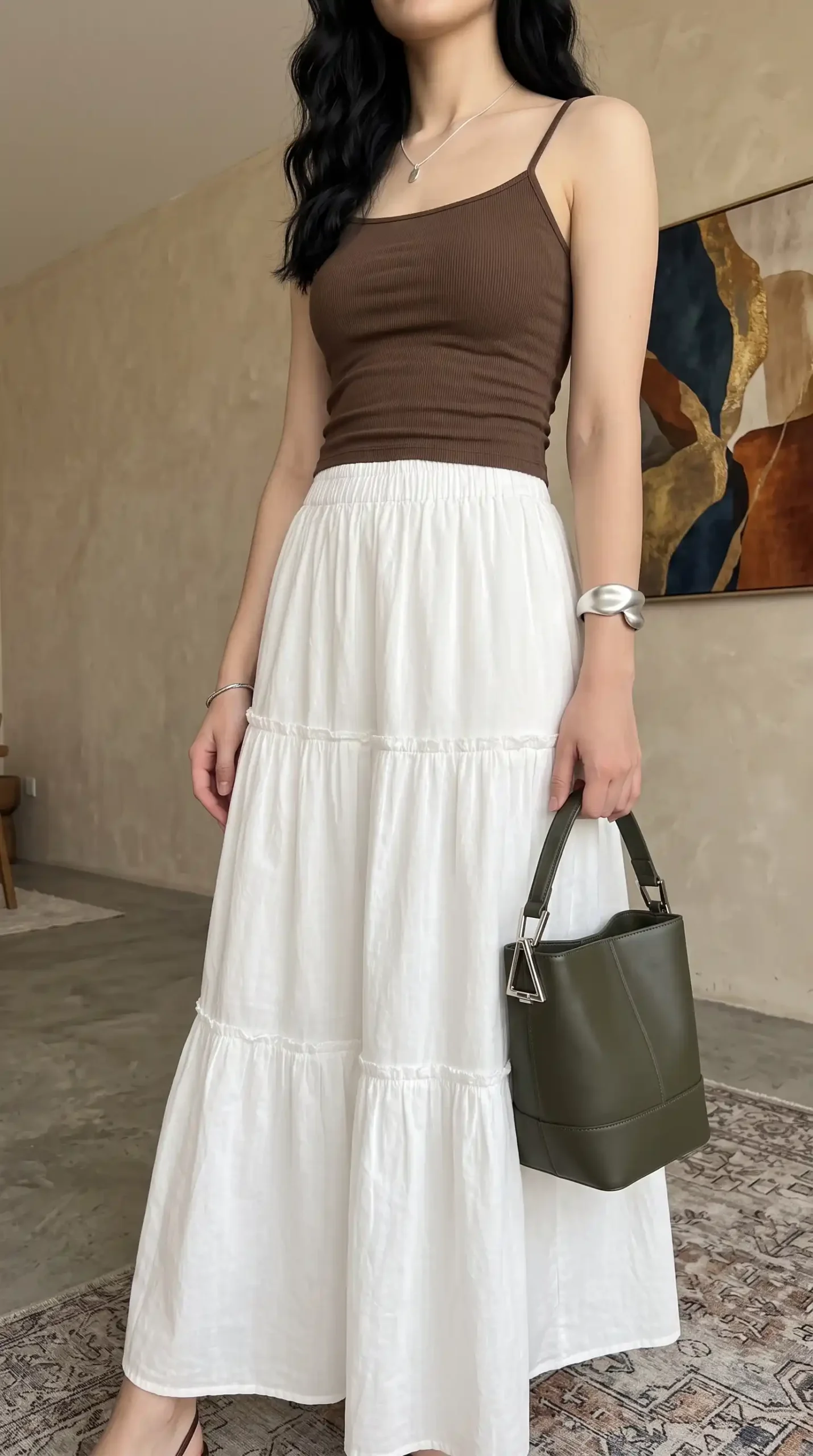 Woman wearing brown ribbed cami top with white tiered maxi skirt and brown sandals