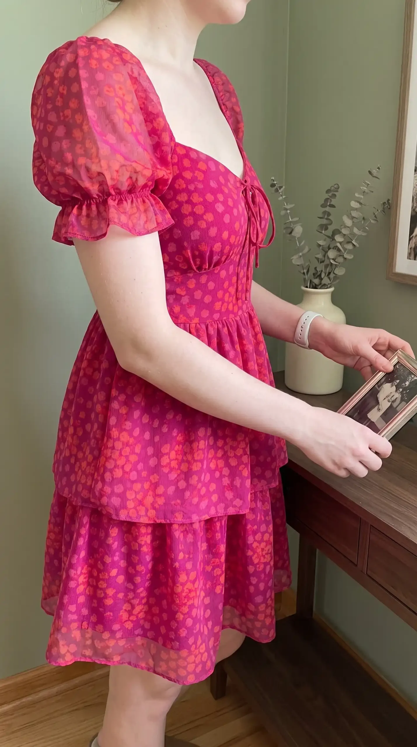 Woman wearing hot pink textured mini dress with off-shoulder puff sleeves and tiered skirt