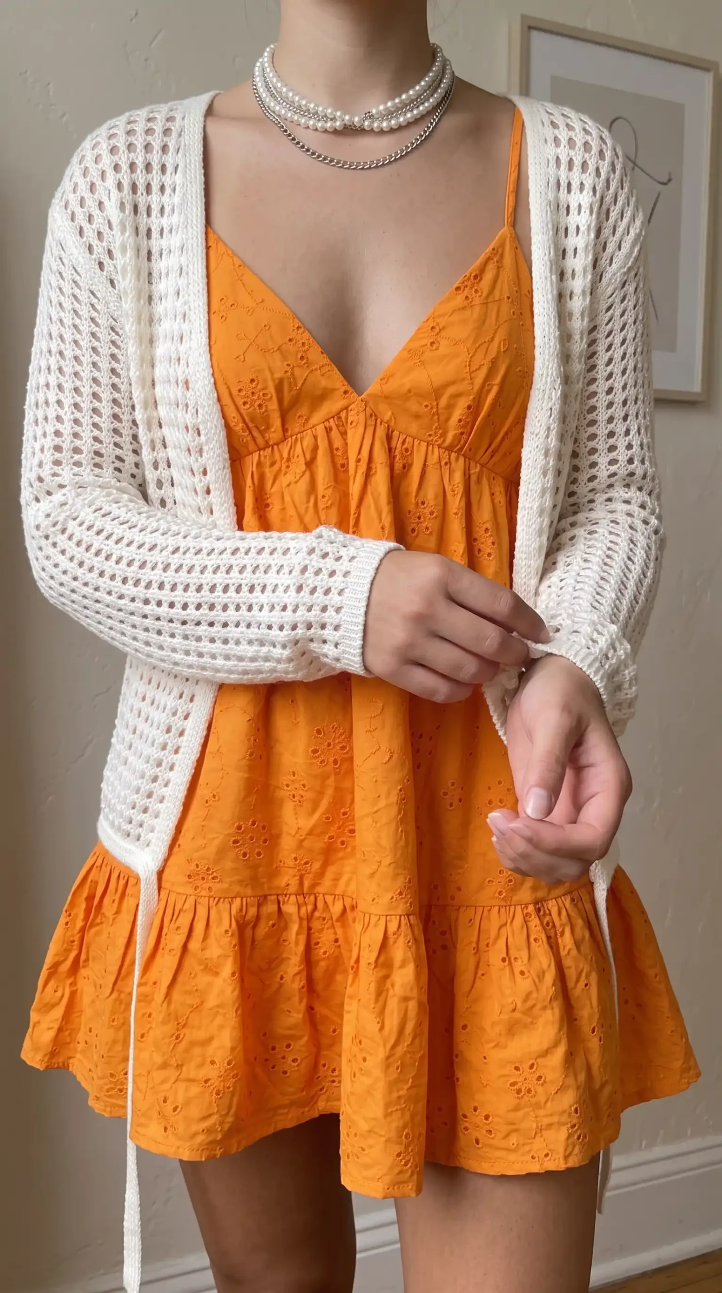 Woman wearing orange babydoll mini dress with square neckline
