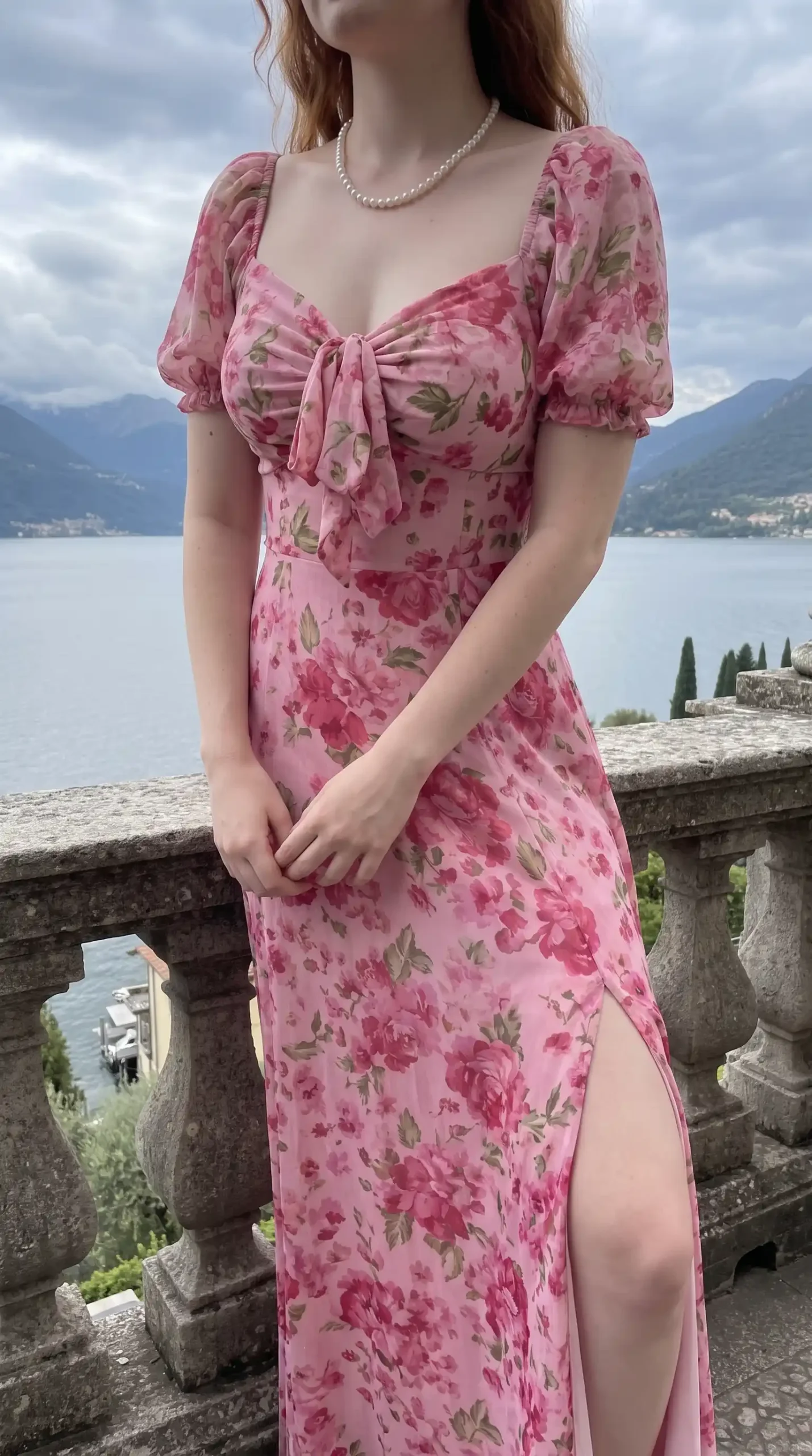 Woman wearing pink floral maxi dress with puff sleeves and woven basket bag by the lake