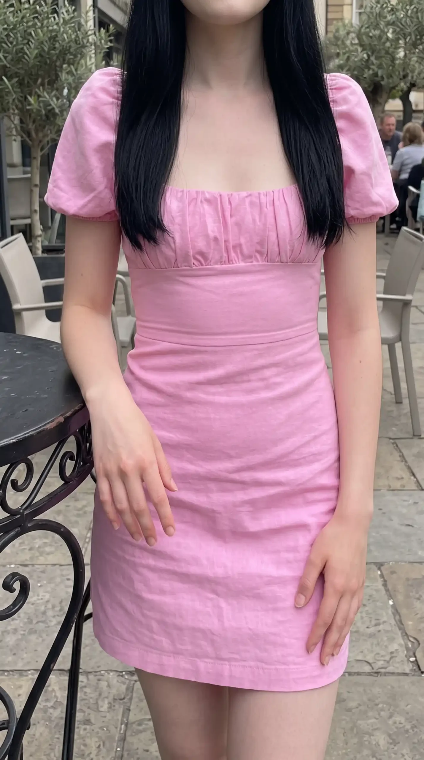 Woman wearing pink ruched mini dress with puff sleeves