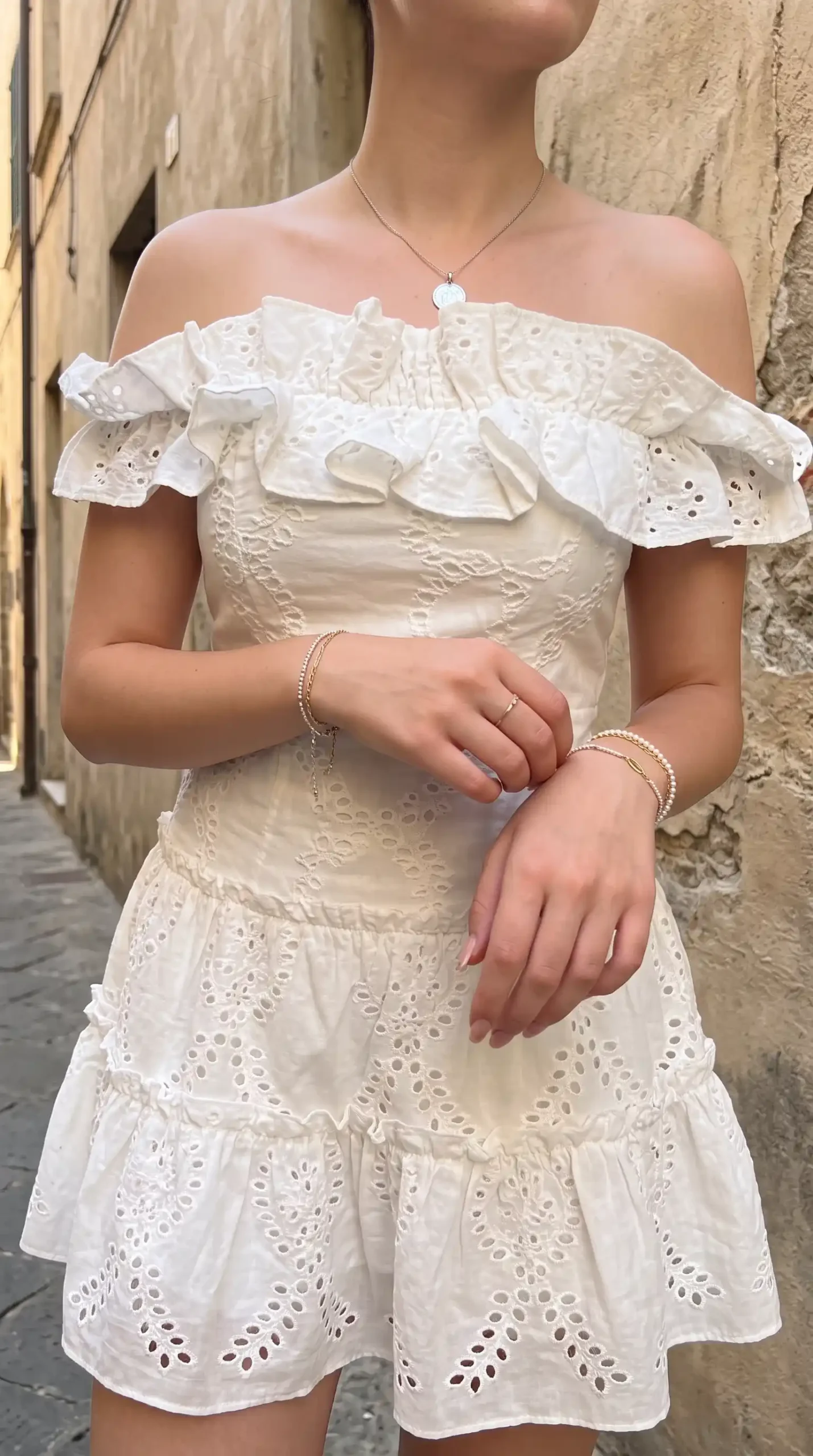 Woman wearing white eyelet off-shoulder mini dress