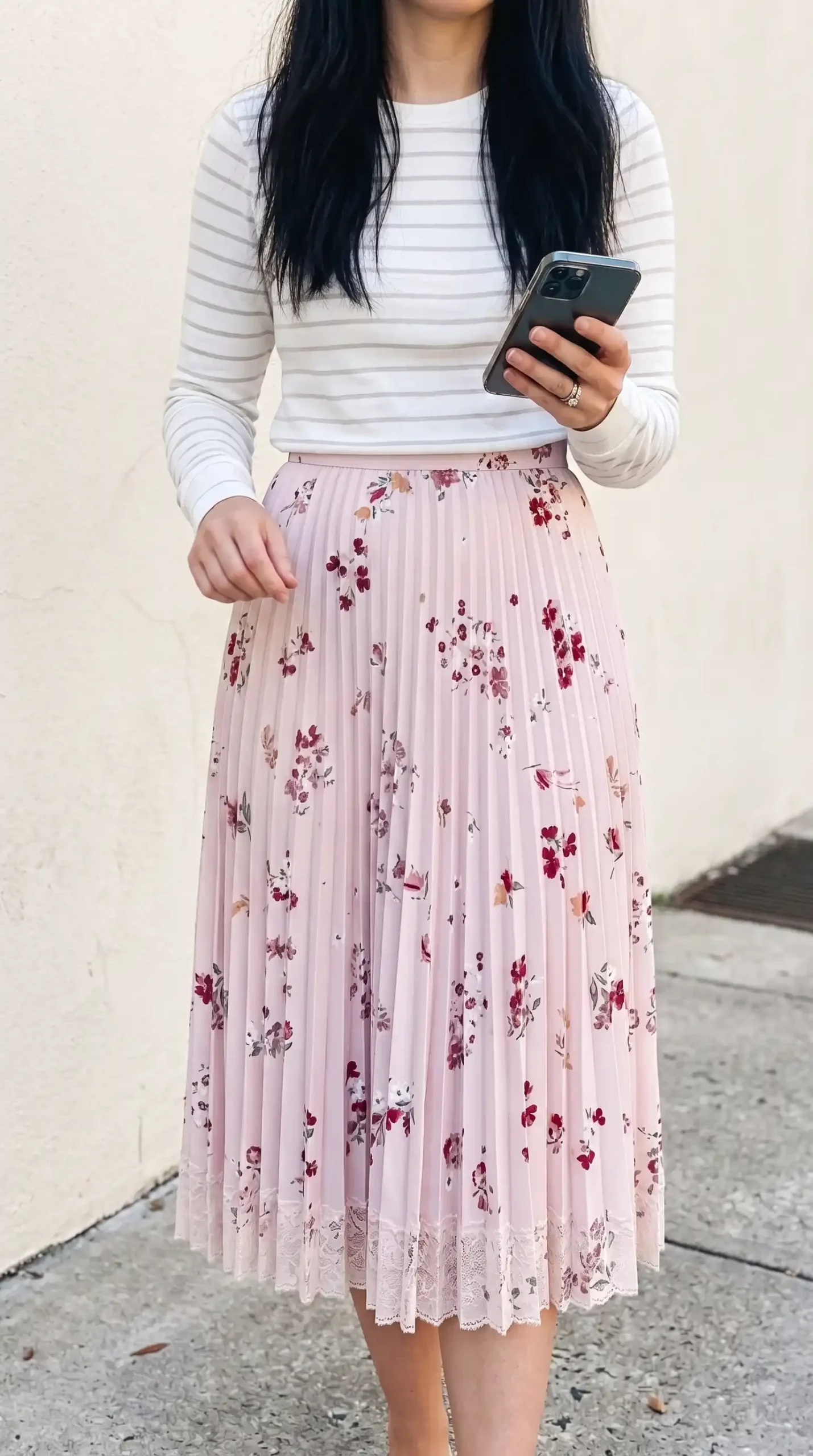 Woman wearing white striped long sleeve top with blush pink floral pleated midi skirt