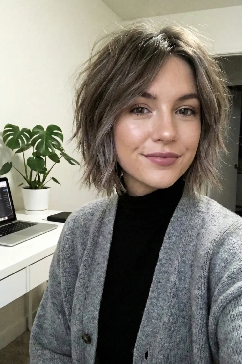 Woman with ash brown tousled shag bob and choppy layers