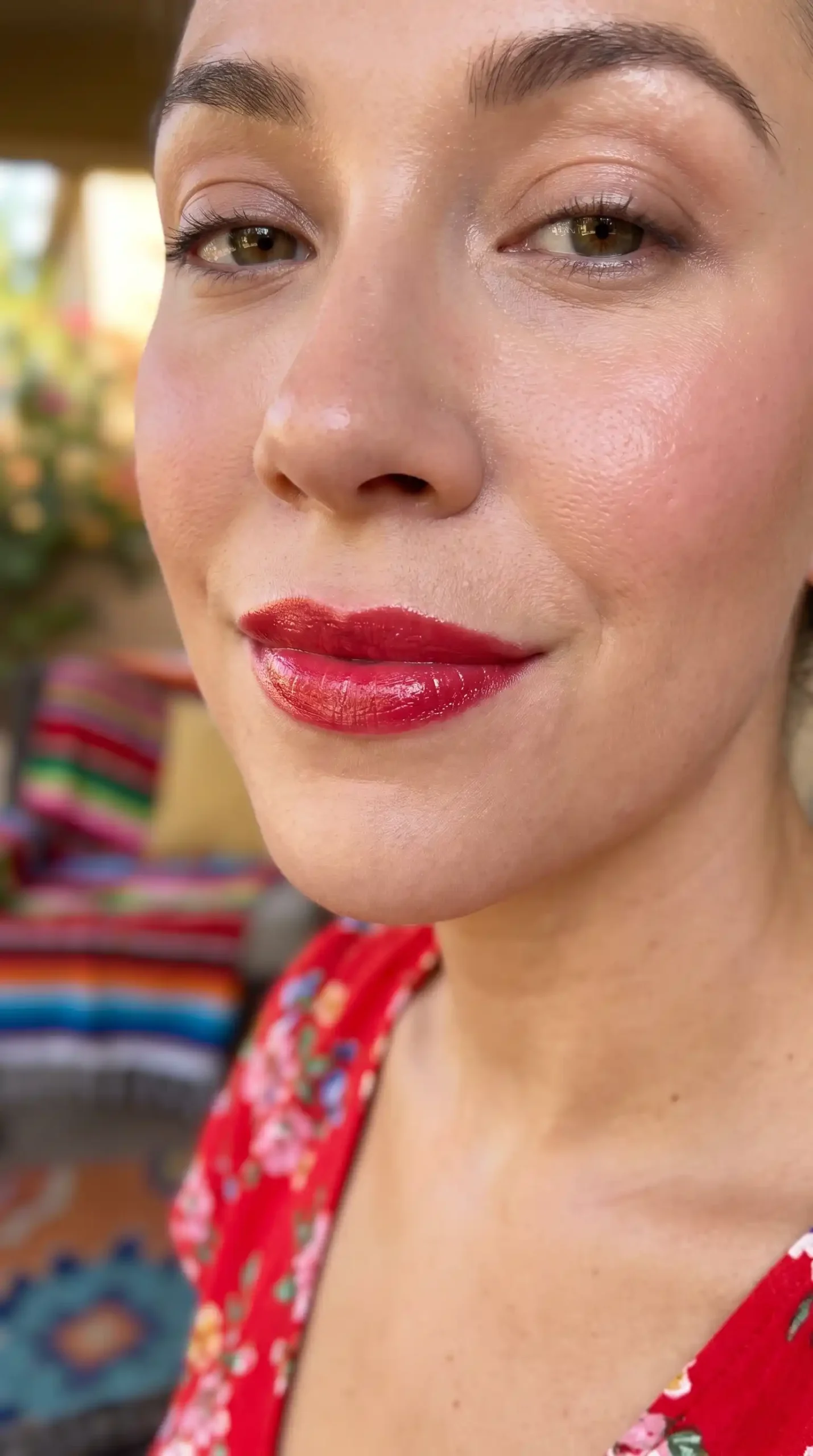Woman wearing candy red bright glossy satin lipstick with fresh vibrant makeup