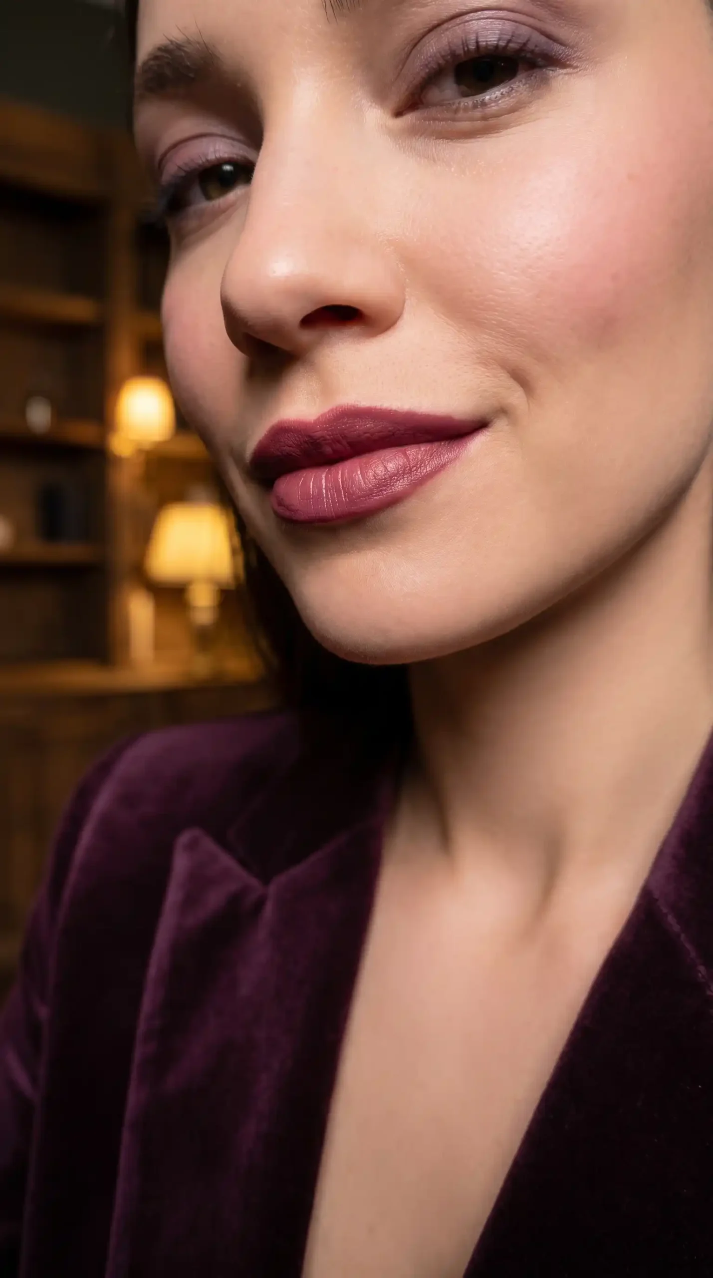 Woman wearing deep plum rose rich satin lipstick with elegant makeup