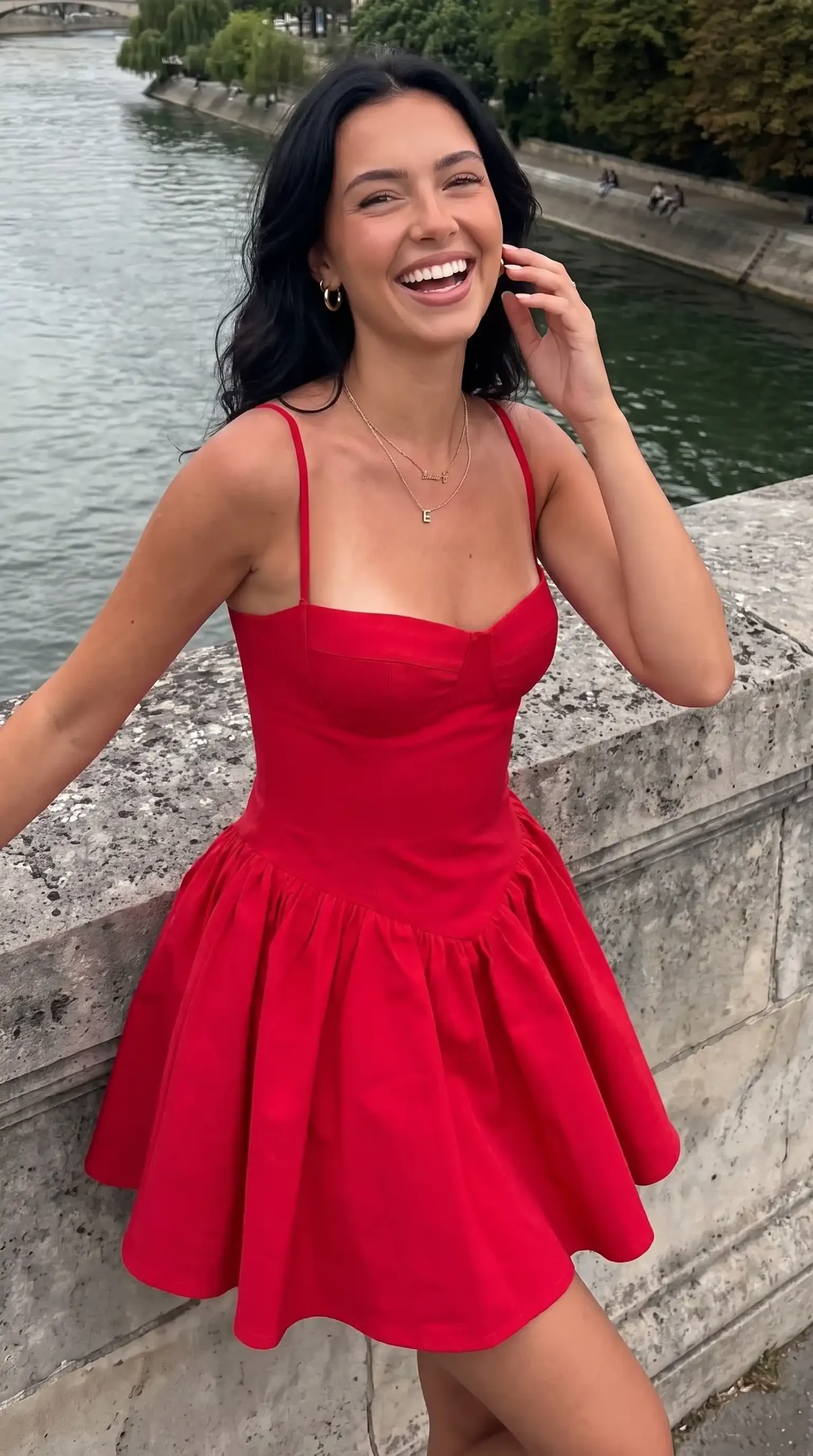 Woman wearing red bustier drop waist skater mini dress by river