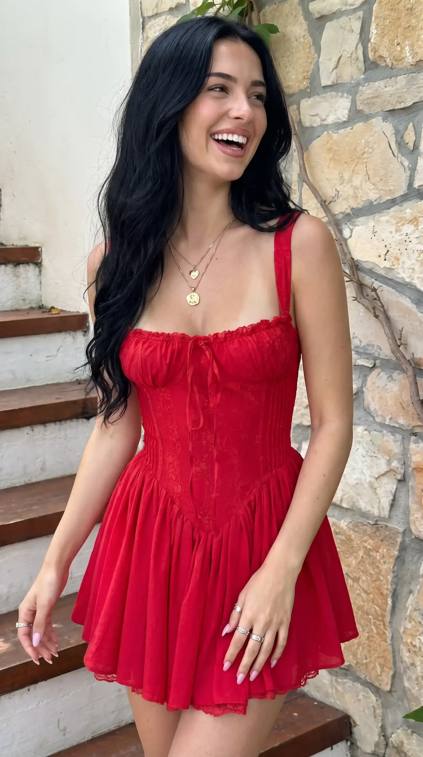 Woman wearing red lace corset tie front babydoll mini dress outdoors