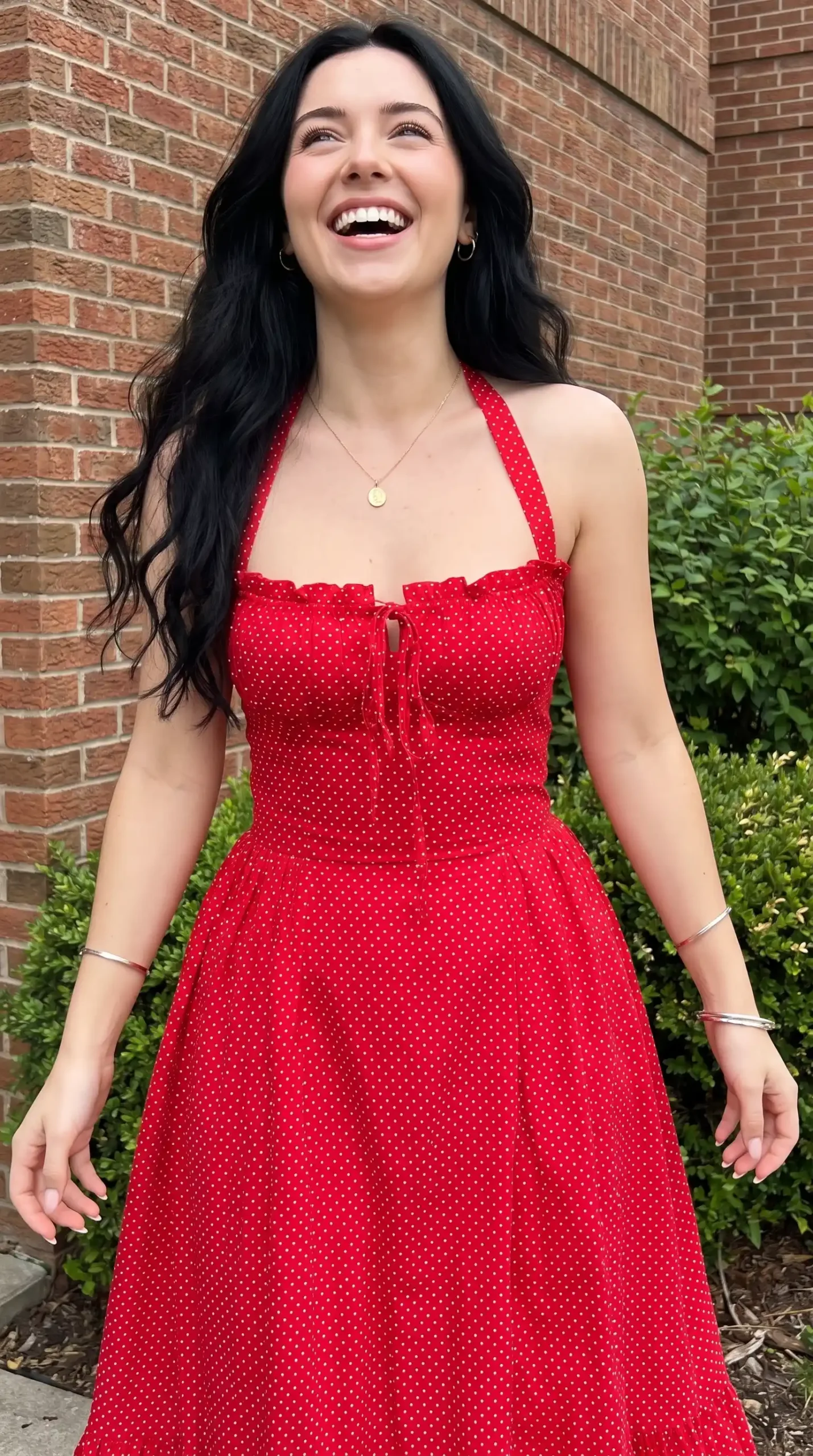 Woman wearing red polka dot halter neck tie front midi dress outdoors