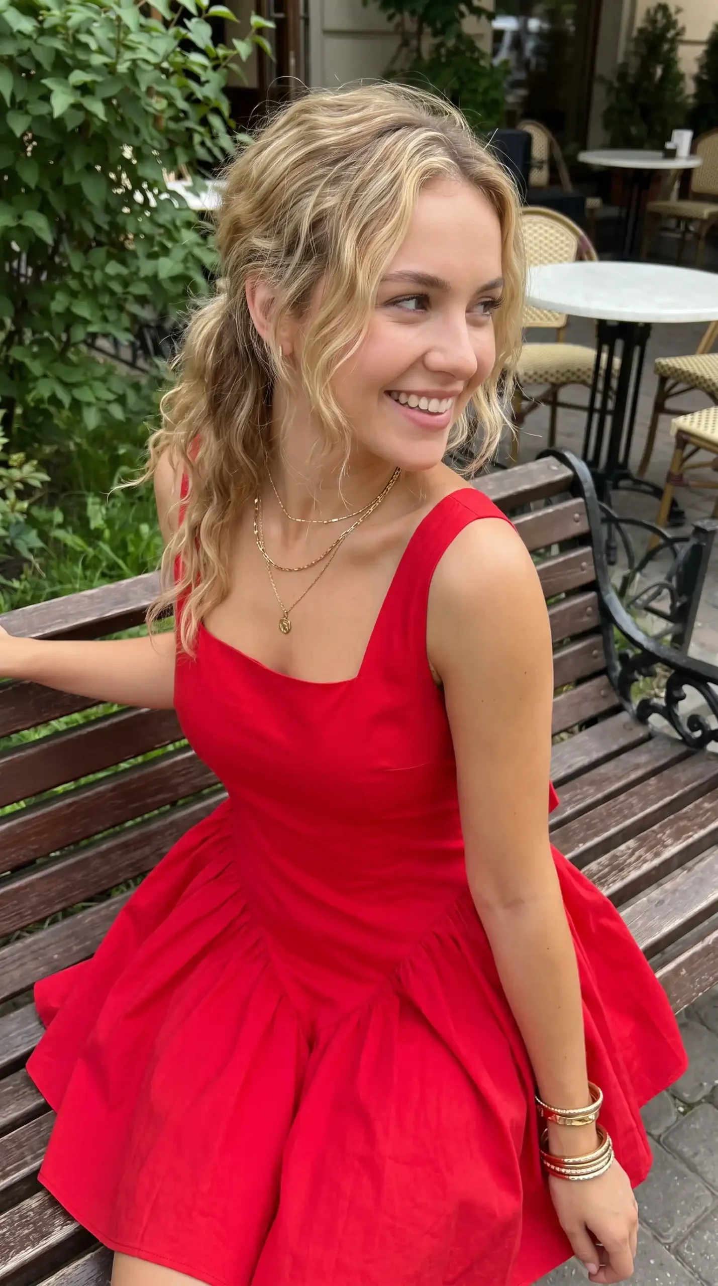 Woman wearing red square neck sleeveless full skirt mini dress sitting on bench