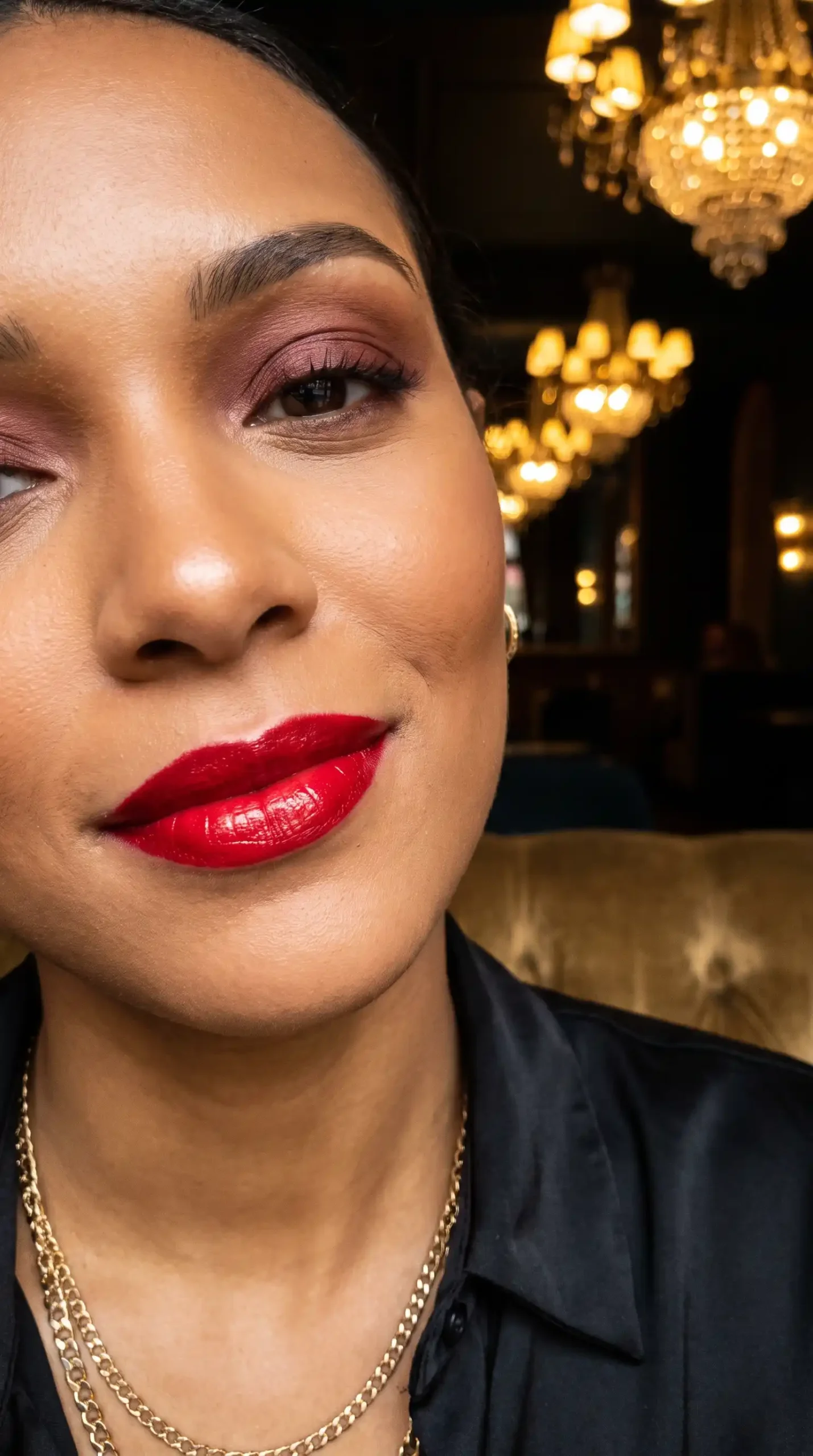 Woman wearing scarlet red bright high shine glossy lipstick