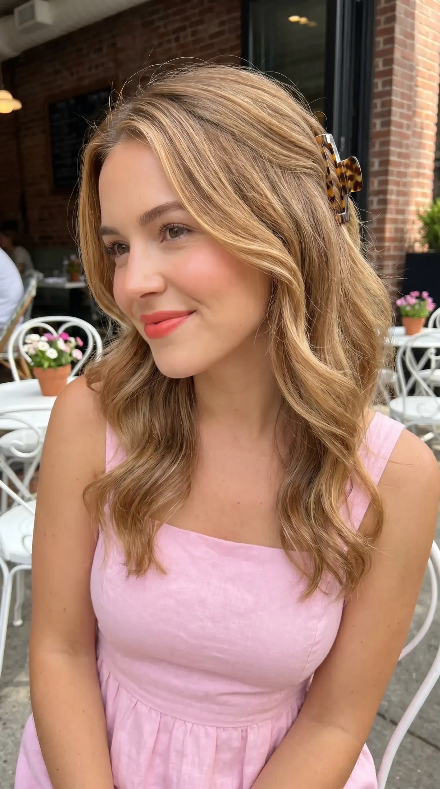 Woman with caramel blonde soft waves and tortoiseshell claw clip