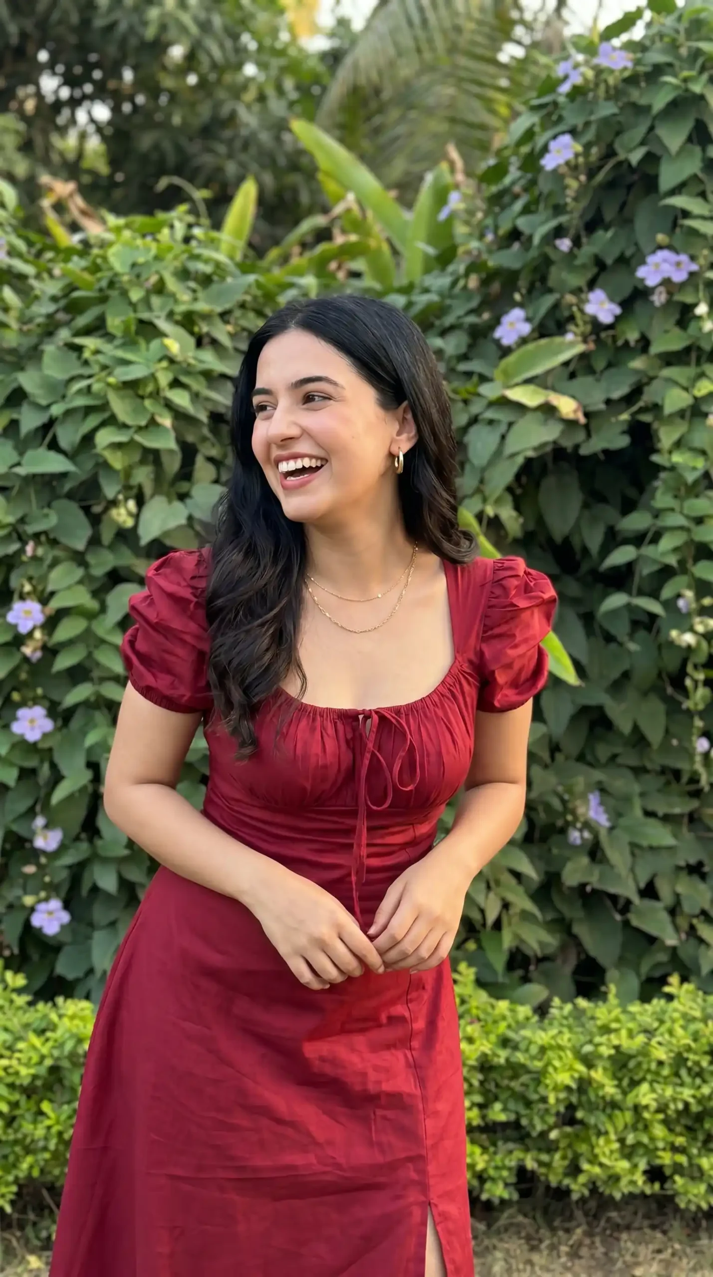Woman wearing deep red puff sleeve tie front square neck midi dress in garden in summer