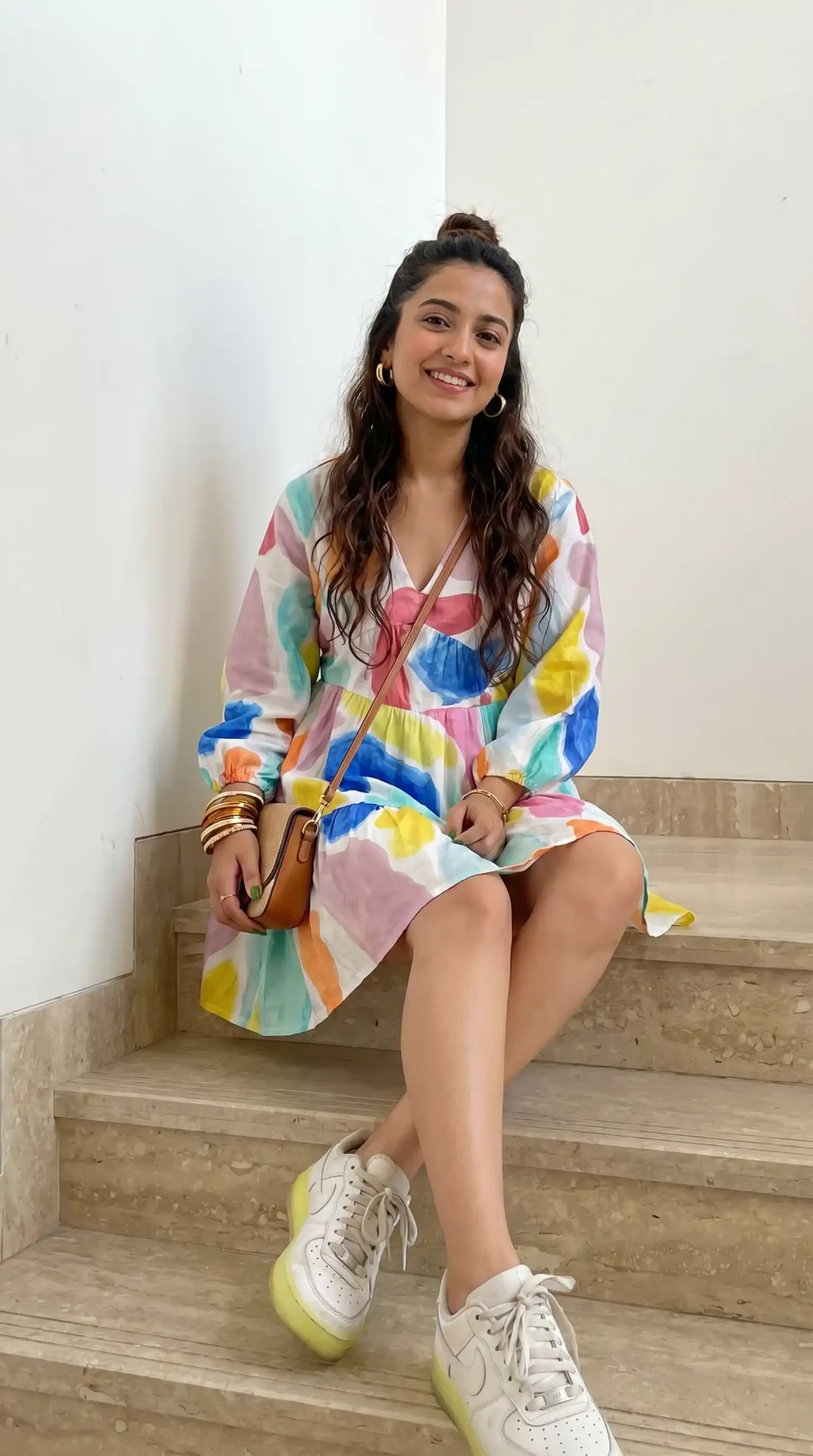 Woman wearing multicolor watercolor print long sleeve dress with white sneakers