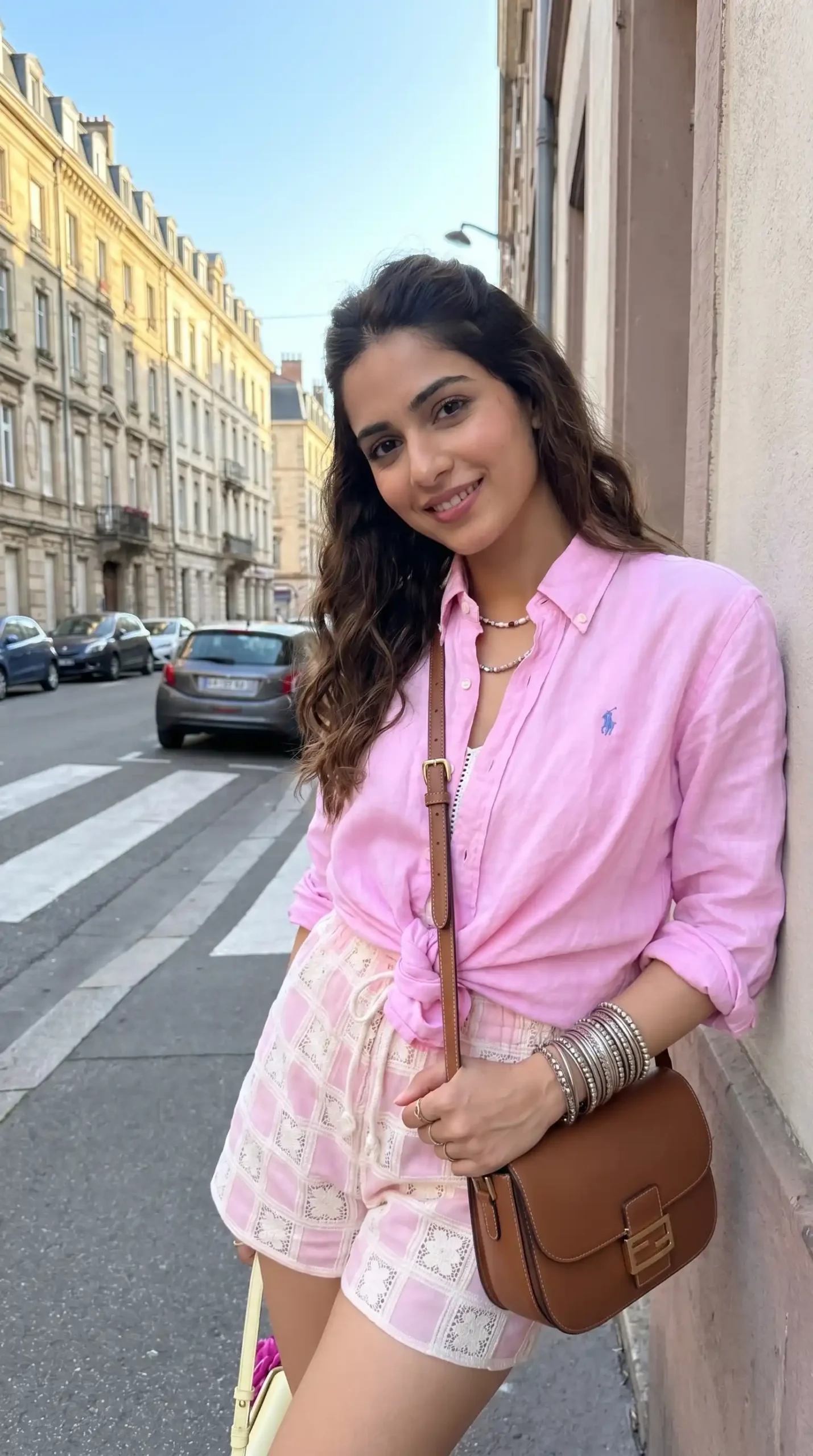 Woman wearing pink button-up shirt with pink and white checkered mini skirt in European city