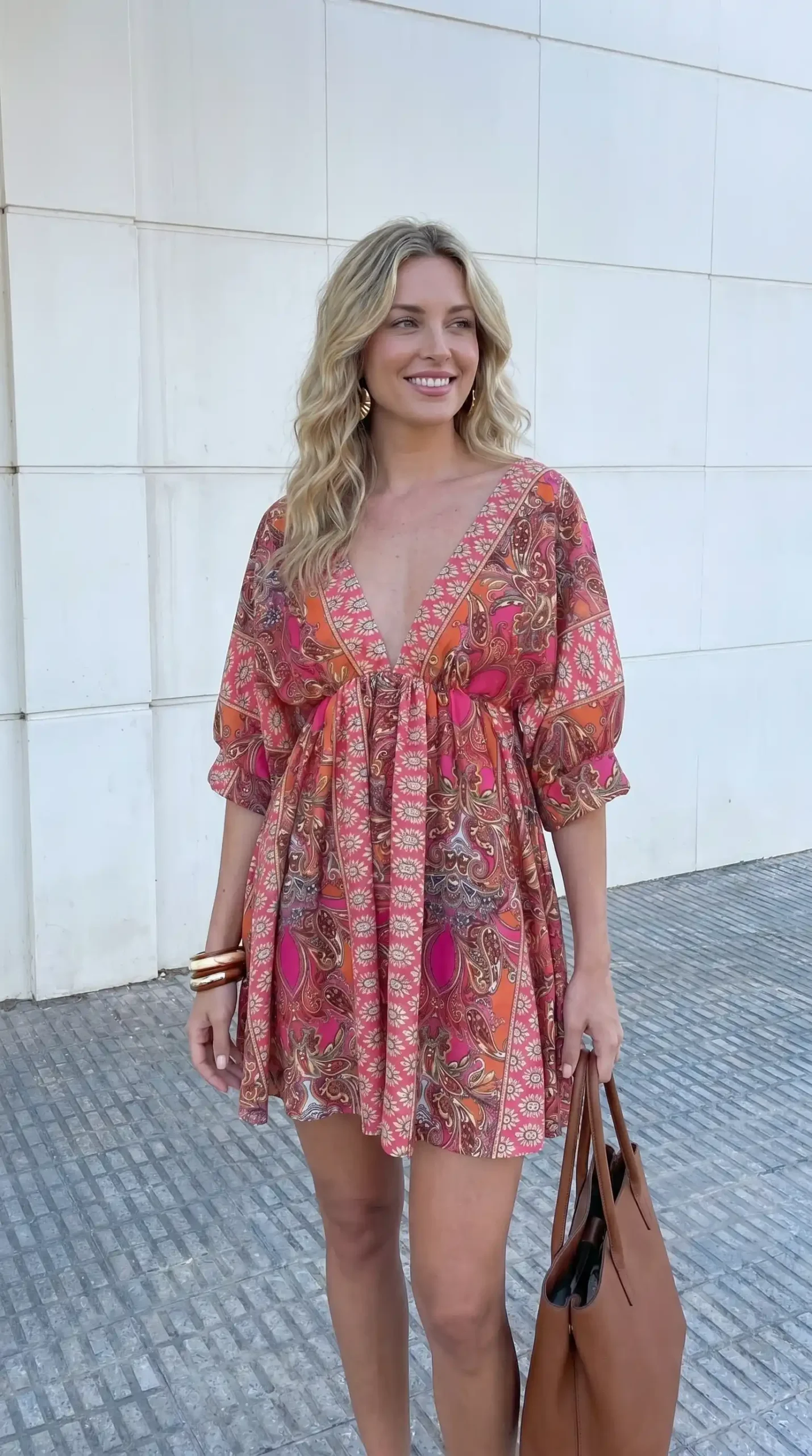 Woman wearing pink red orange paisley wrap dress with three quarter sleeves