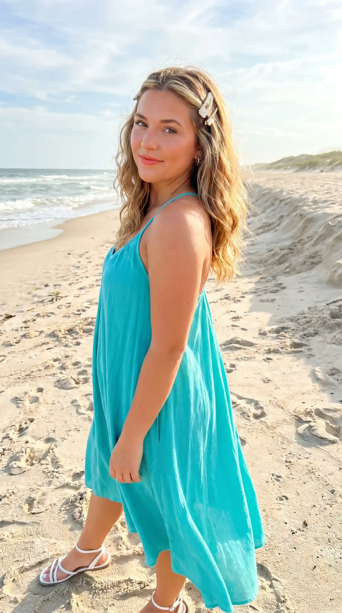 Woman with caramel blonde tousled beach waves and decorative pearl clips