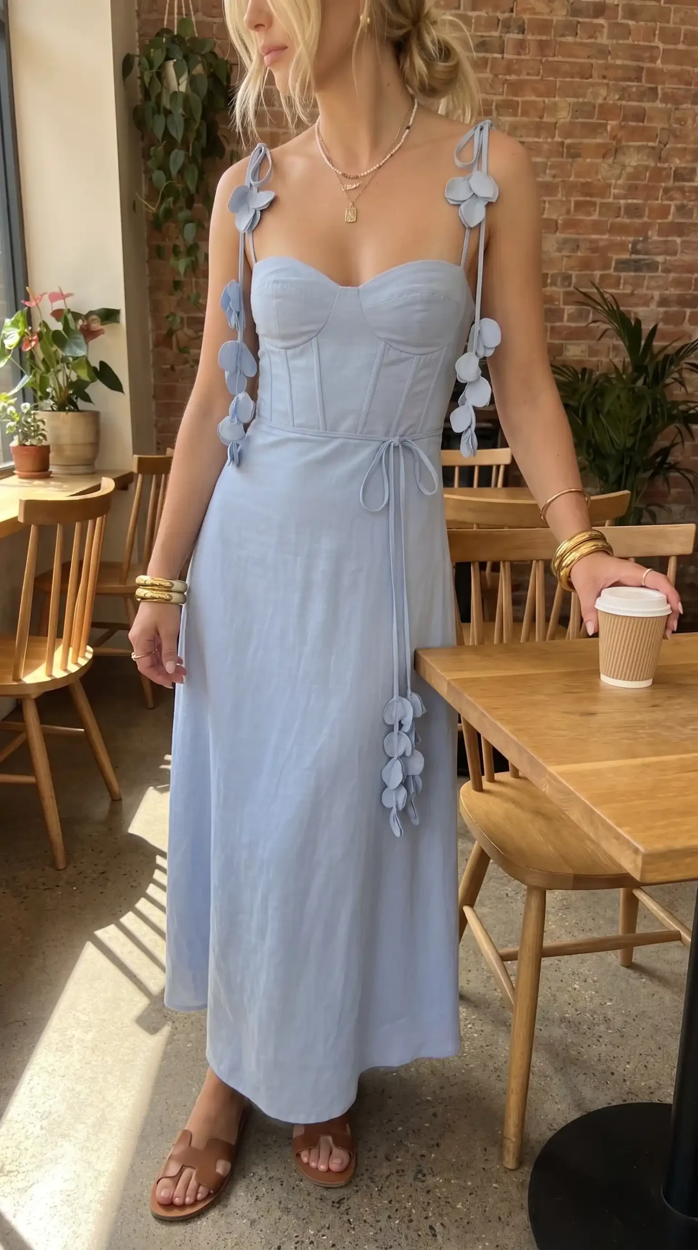 Woman wearing baby blue petal strap corset maxi dress with tan sandals