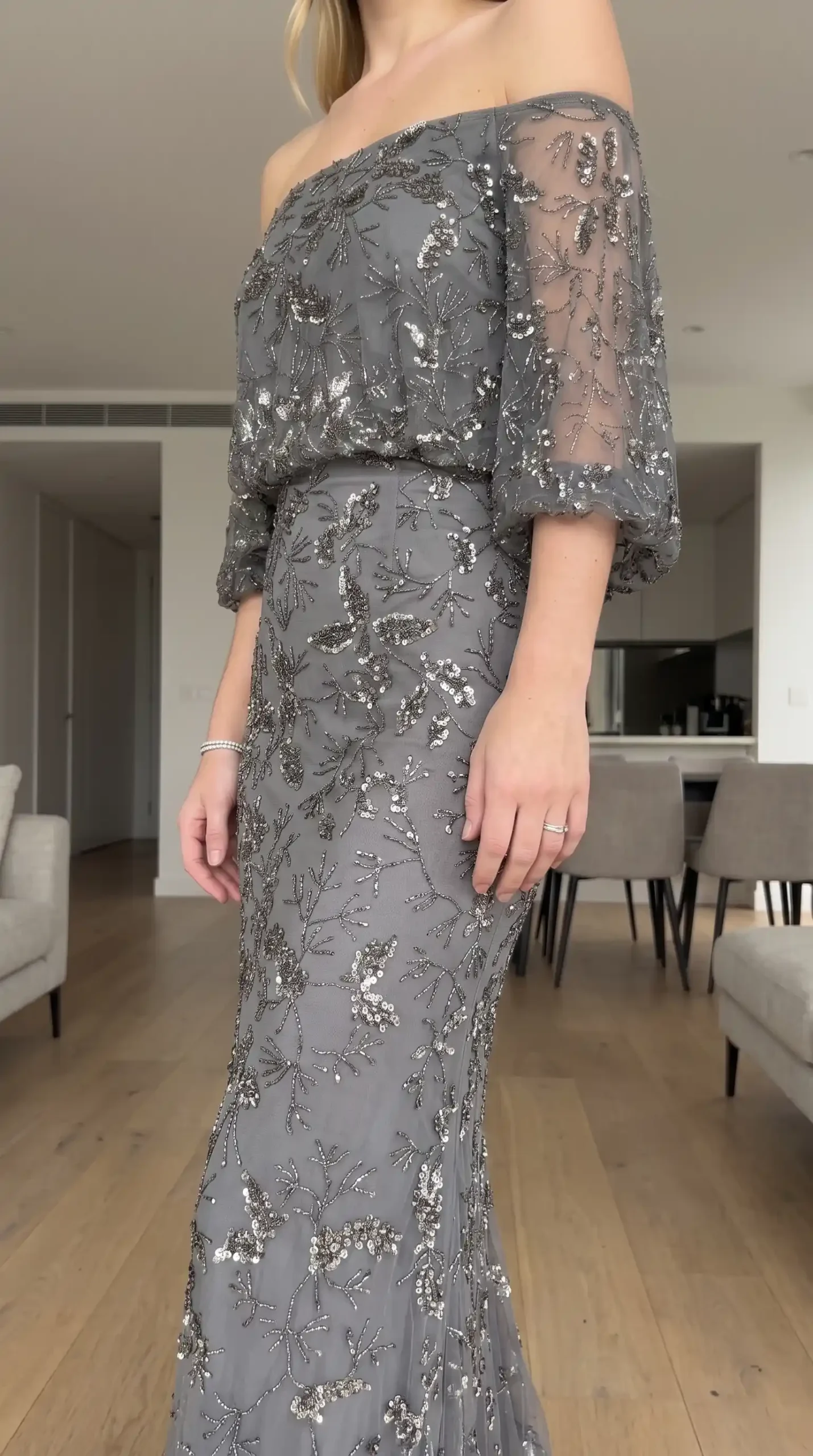 Woman wearing grey silver sequin floral beaded off shoulder blouson mermaid maxi dress