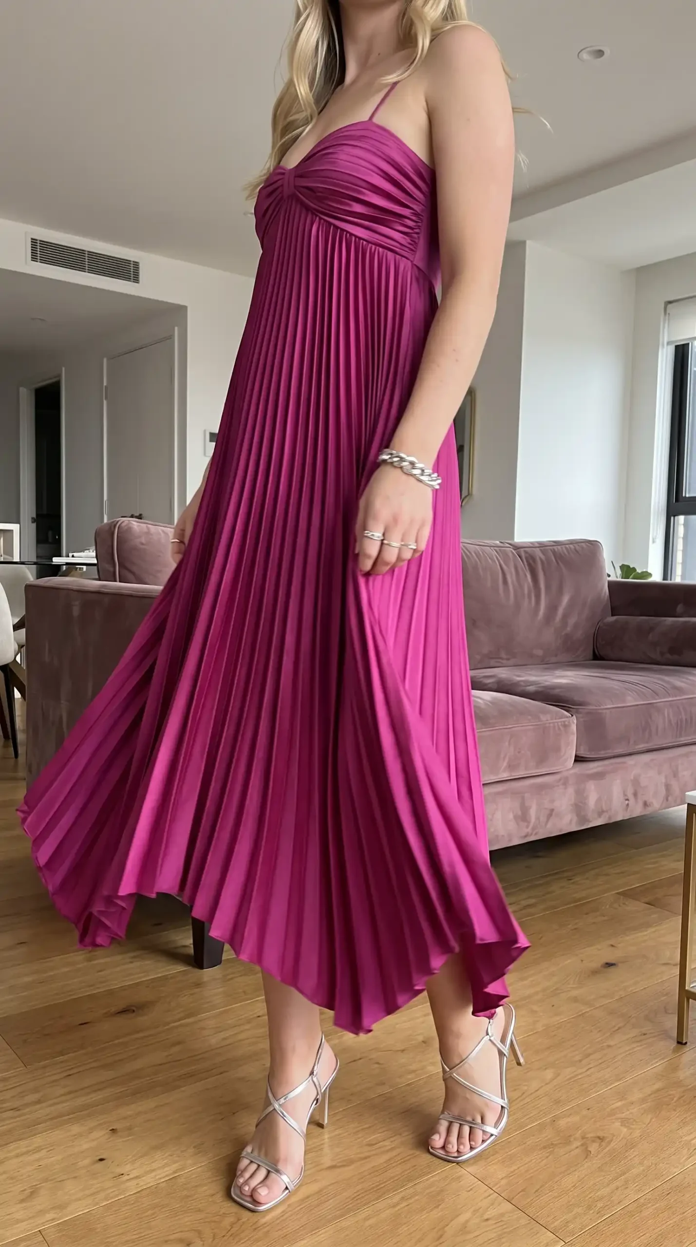 Woman wearing magenta pleated halter neck midi dress with silver heels