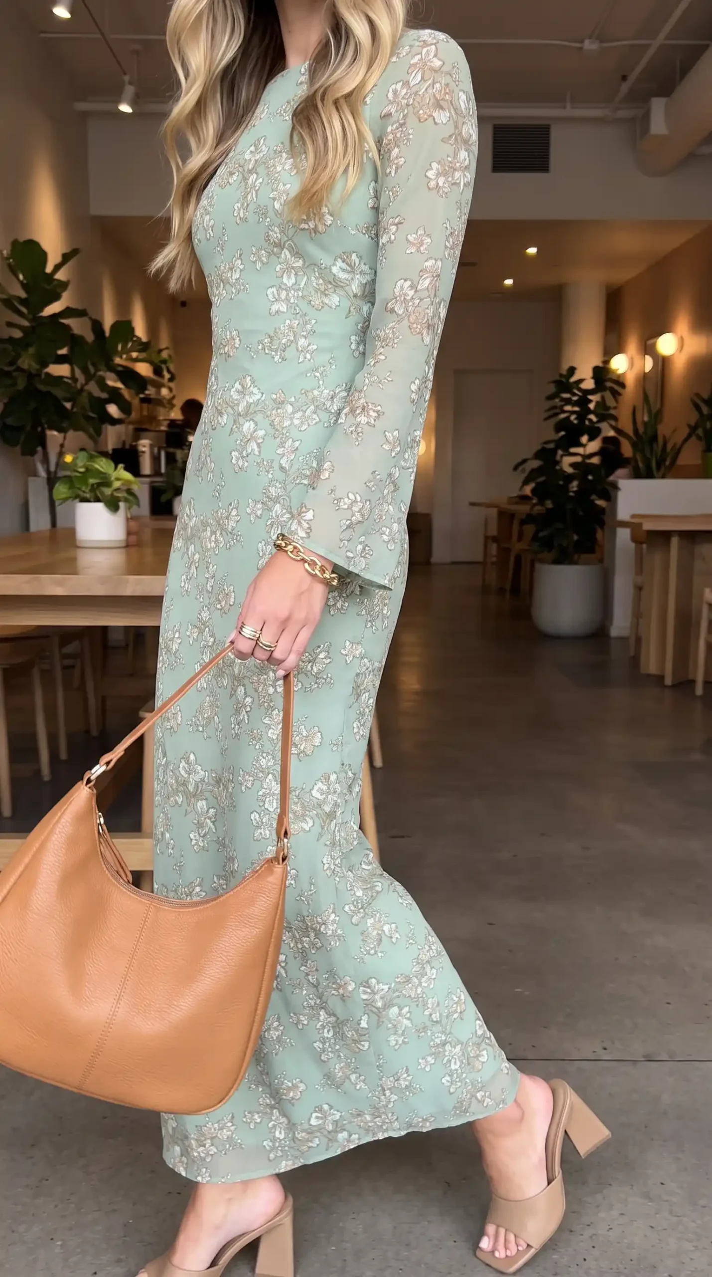 Woman wearing mint green floral long sleeve fitted maxi dress with tan bag and nude heels